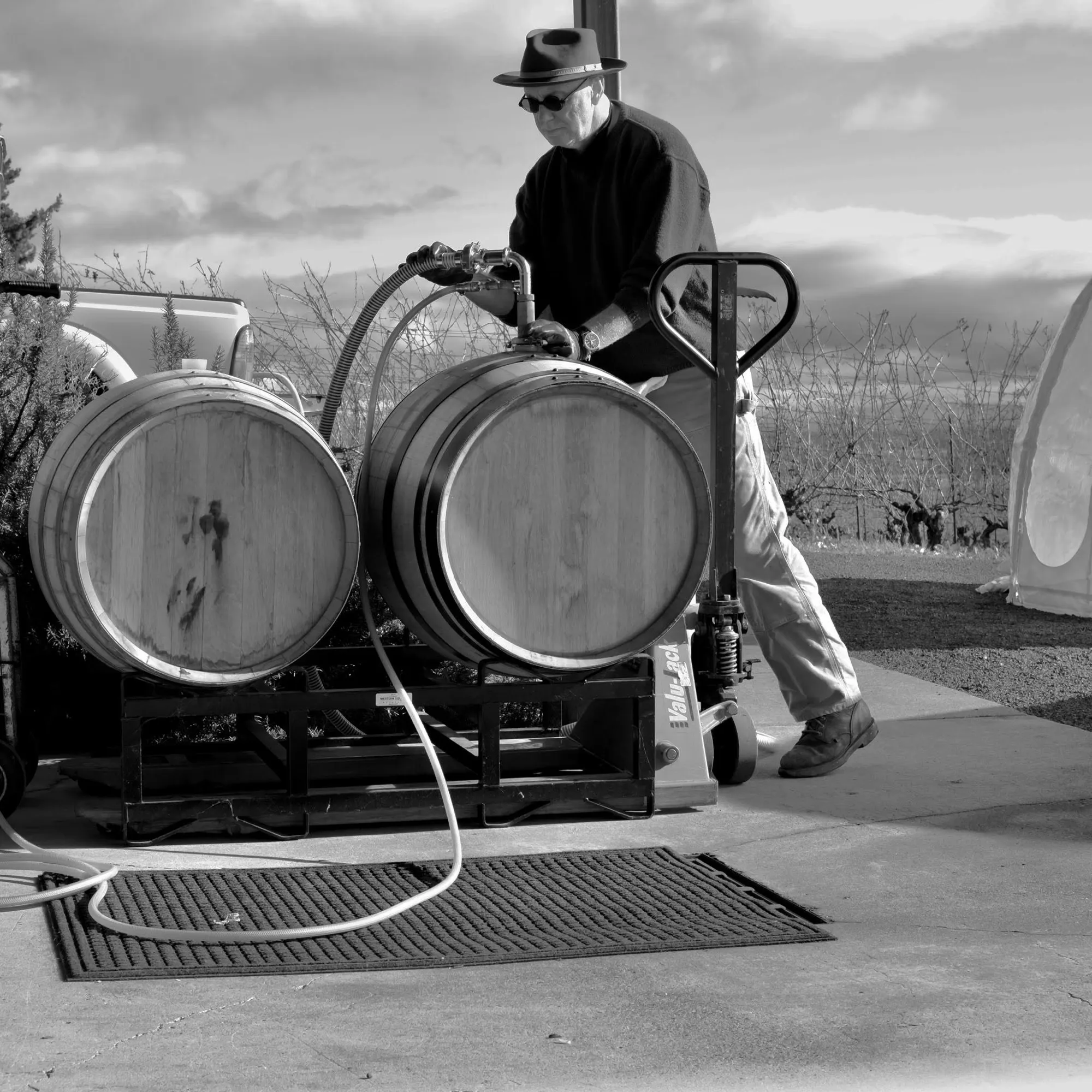 Owner Bill Sweat moving wine to barrel